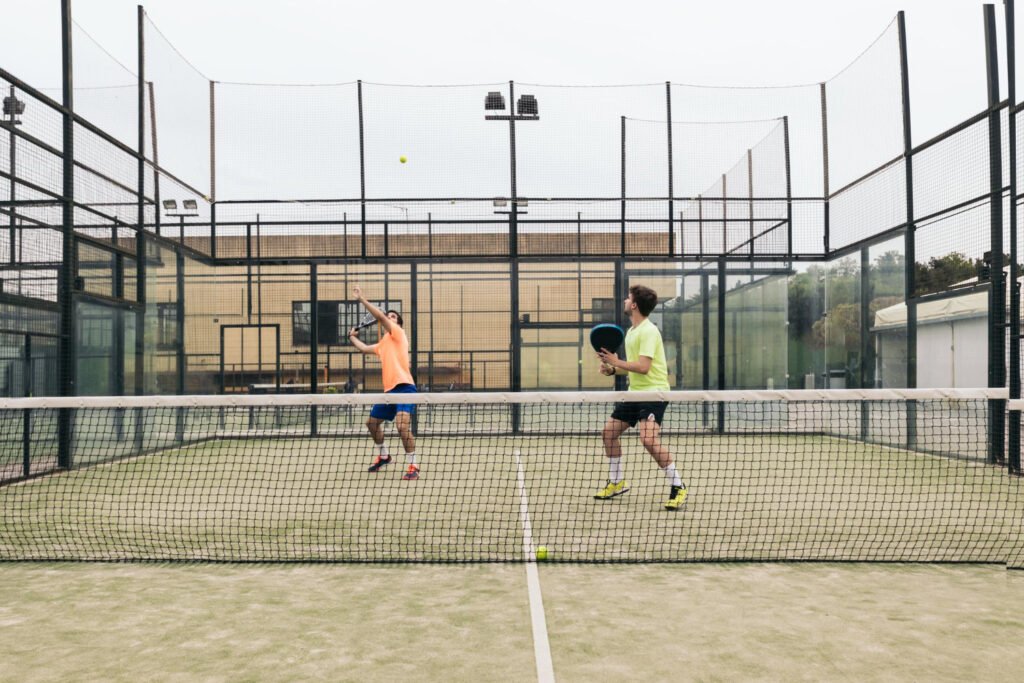 Comparaison entre un terrain de padel fermé et un court de tennis ouvert.