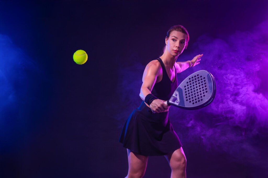 Terrain de padel avec filet, vitres et quatre joueurs.