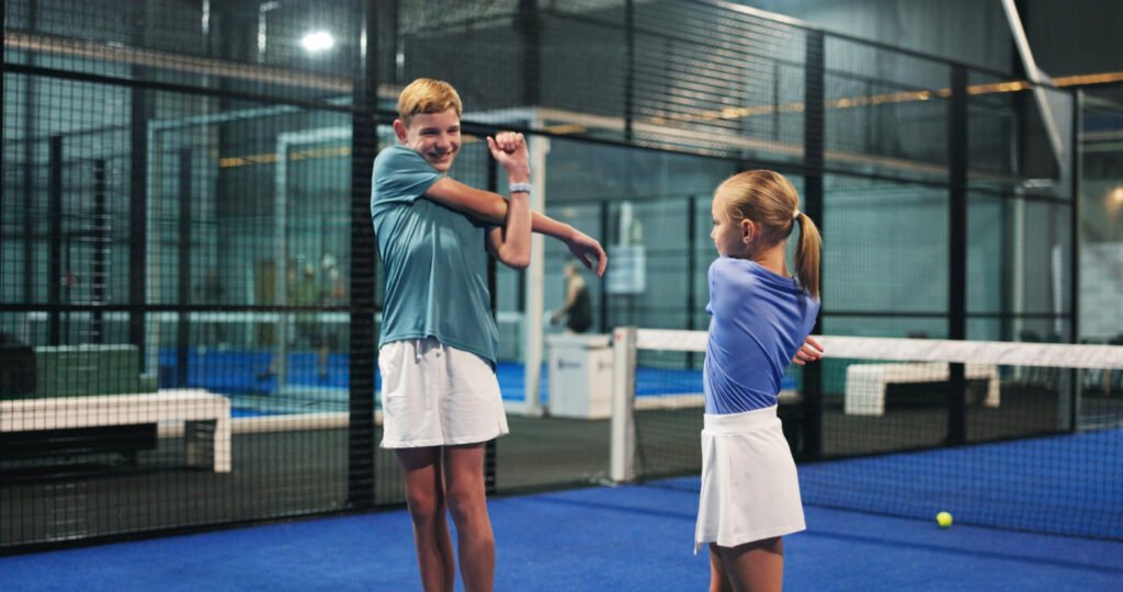 Joueurs débutants découvrant le padel sur un terrain en double.