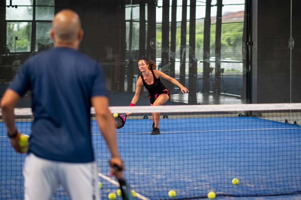 Deux partenaires de padel coordonnés pendant un échange en double.
