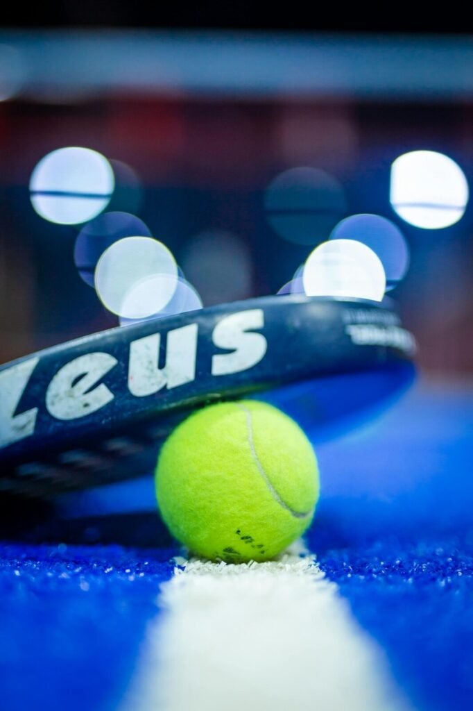 Balle et raquette de padel sur une piste bleue
