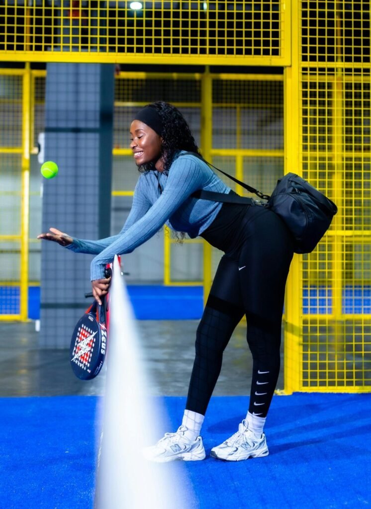 Joueuse de padel récupérant une balle près du filet