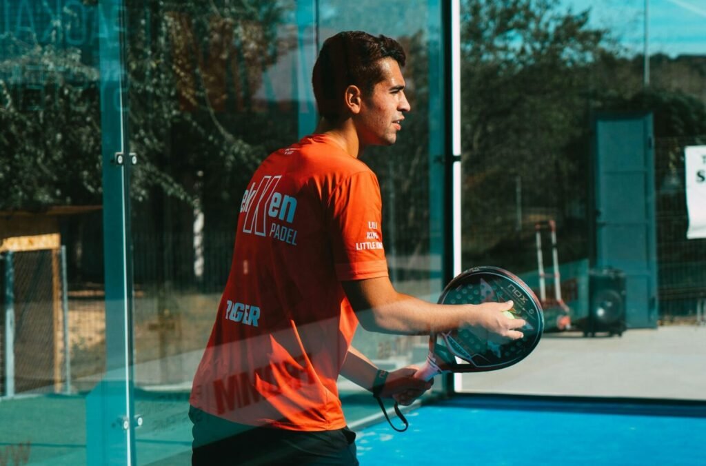 Joueur de padel attentif devant une vitre